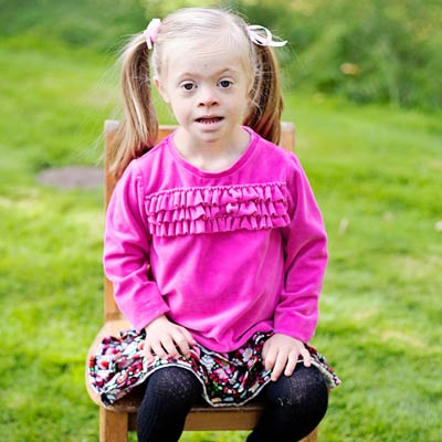 Girl in pink shirt sitting on chair